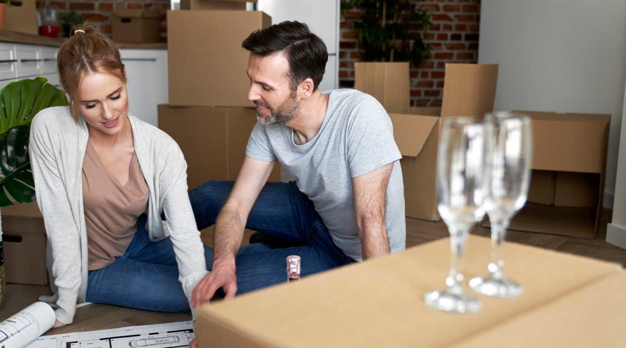 couple sitting on floor looking at wine cellar designs